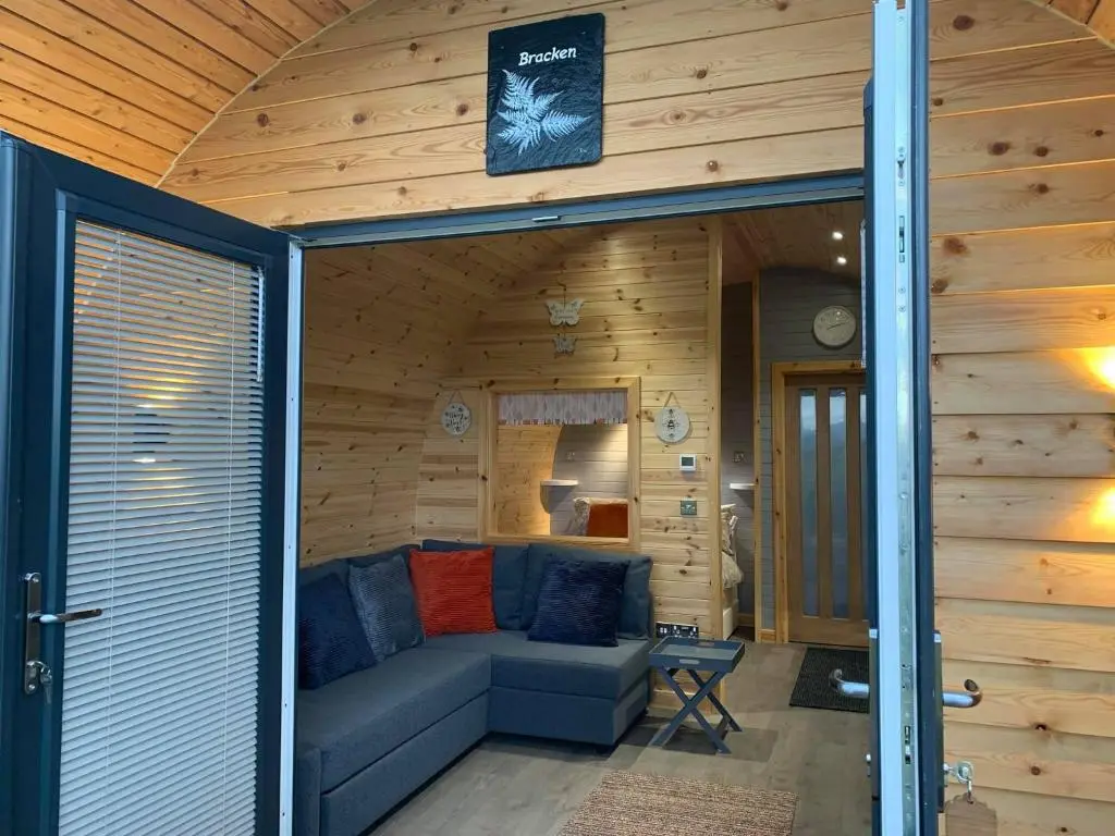 a living room with a couch in a wooden house at Daviot Luxury Pods in Inverness