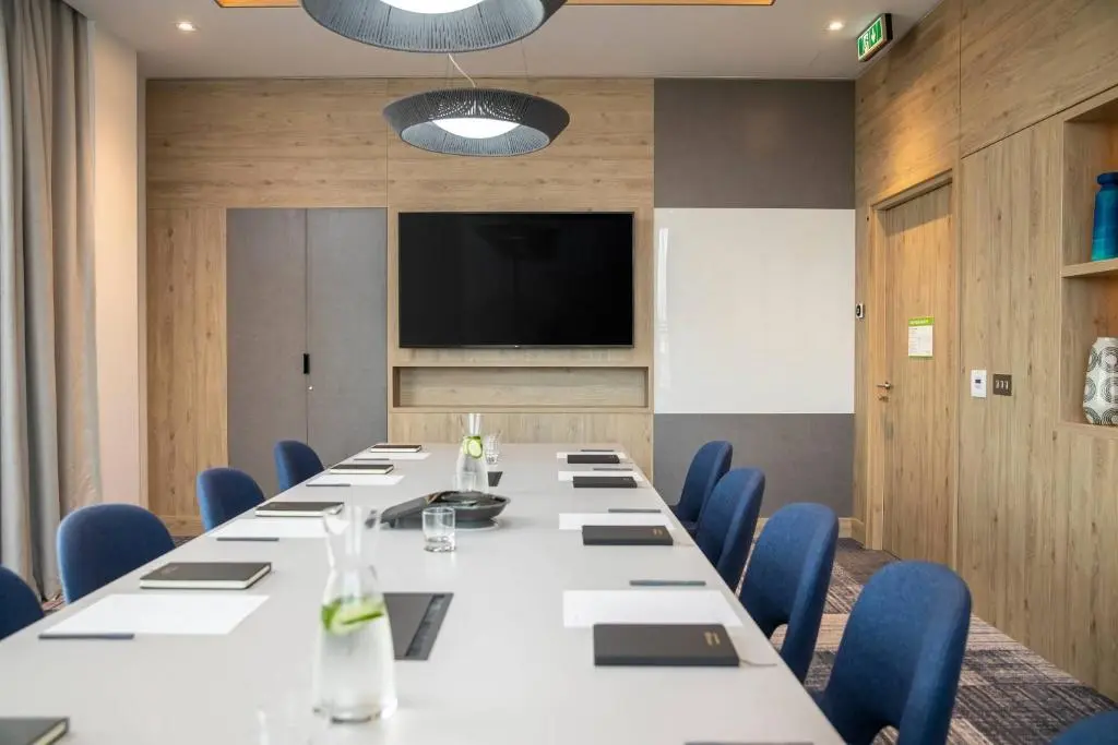 a conference room with a long table and blue chairs at Courtyard by Marriott Inverness Airport in Inverness