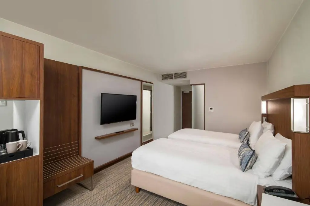 a hotel room with a bed and a flat screen tv at Courtyard by Marriott Inverness Airport in Inverness
