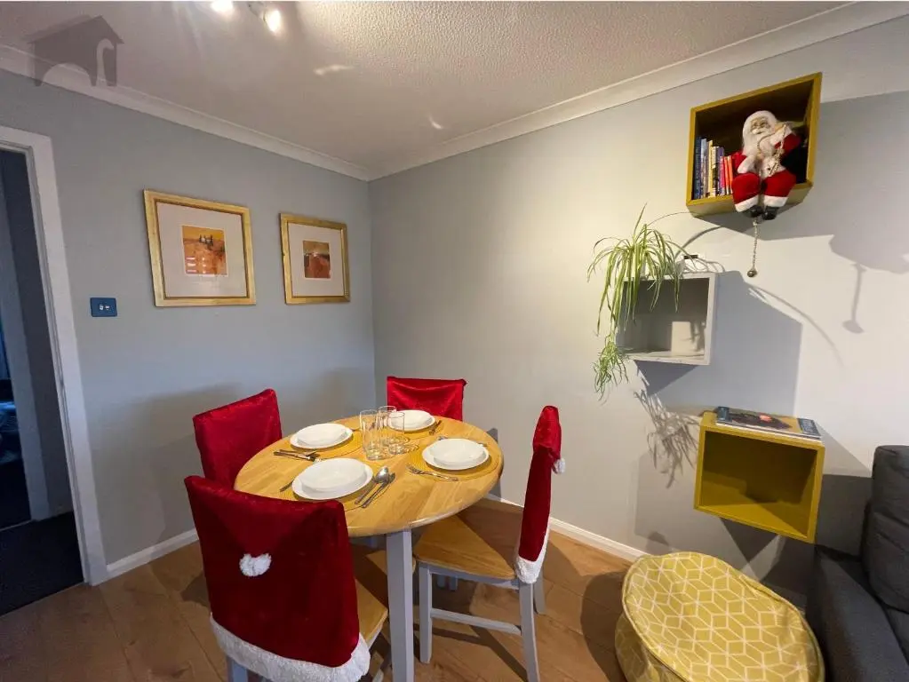 a dining room with a table and red chairs at Highfield apartment in Inverness