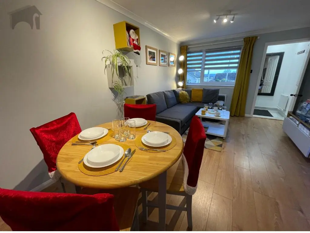 a living room with a table and red chairs at Highfield apartment in Inverness