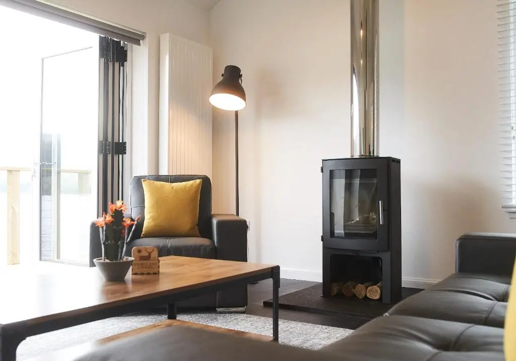 a living room with a couch and a fireplace at Shoreland Lodges - Holly Lodge in Fort Augustus