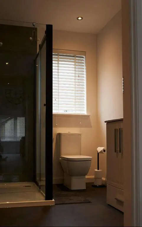 a bathroom with a toilet and a window at Shoreland Lodges - Cherry Lodge in Fort Augustus