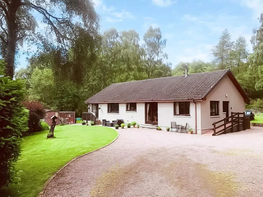 a small white house with a gravel driveway at The Birches in Ardclach