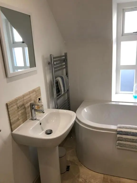 a white bathroom with a sink and a bath tub at Fantastic central location in Inverness