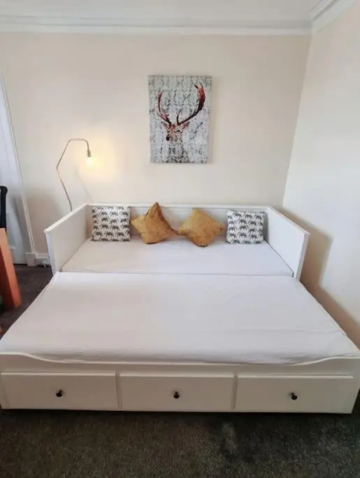a white bed with pillows on it in a room at Highland Historical Home in Inverness City Centre in Inverness