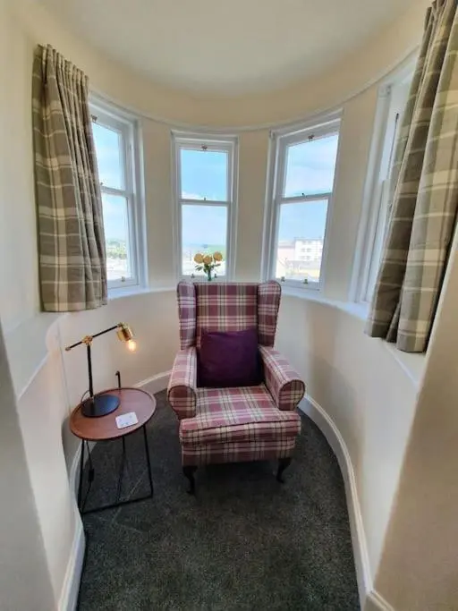 a living room with a chair and a table at Highland Historical Home in Inverness City Centre in Inverness