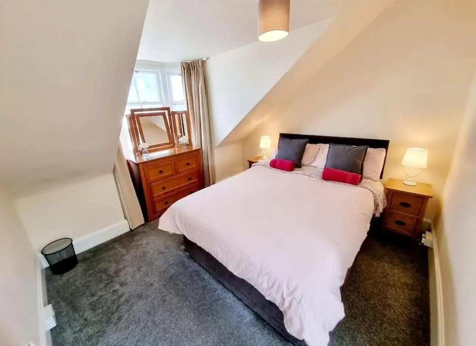 a bedroom with a large white bed with two lamps at Highland Historical Home in Inverness City Centre in Inverness