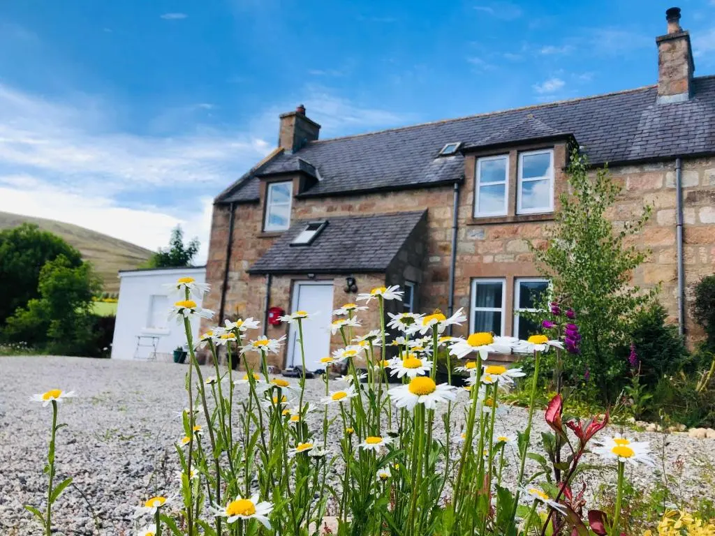 a house with flowers in front of it at Lettoch Farm in Dufftown