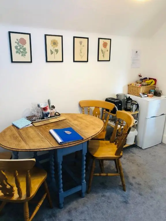 a table and chairs in a room with a refrigerator at Lettoch Farm in Dufftown