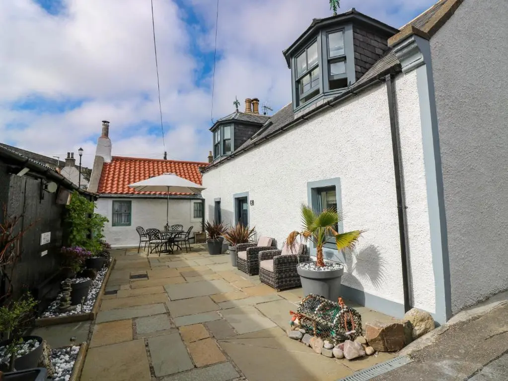 a courtyard of a white building with plants on it at 61 Seatown in Buckie