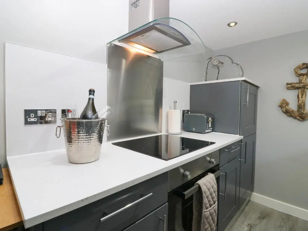 a kitchen with a sink and a bottle of wine at 61 Seatown in Buckie