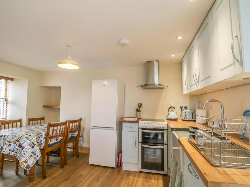a kitchen with a table and a white refrigerator at 11 Village in Banff