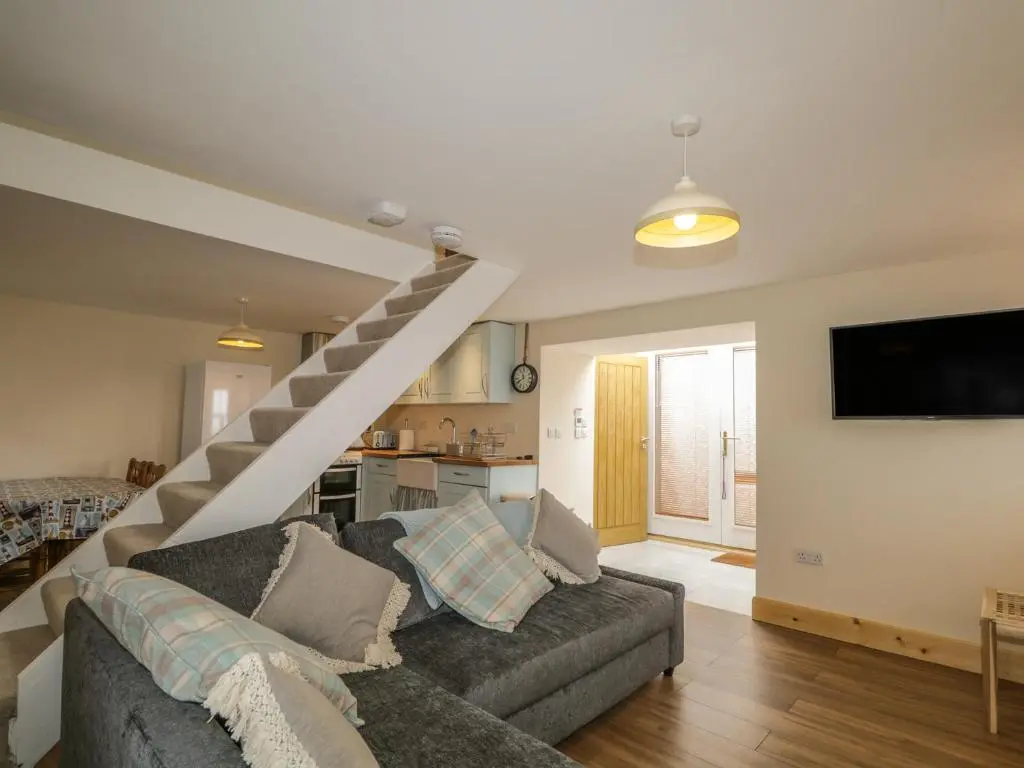 a living room with a couch and a staircase at 11 Village in Banff