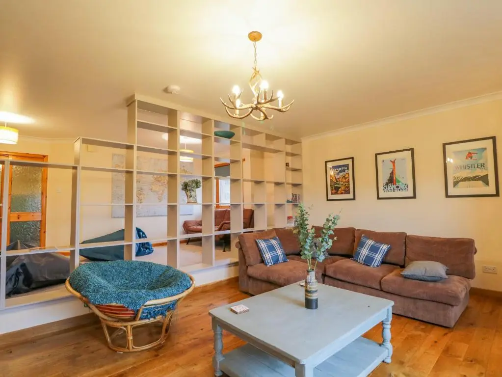 a living room with a couch and a table at Ptarmigan in Carrbridge