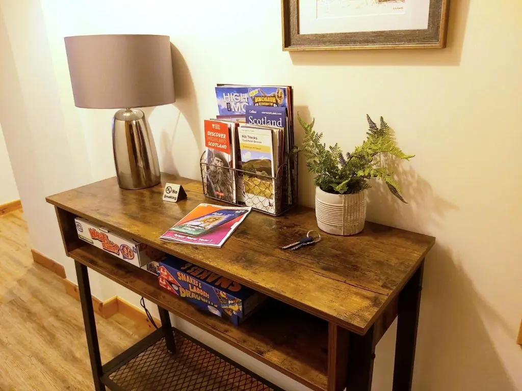 a wooden table with a lamp and a plant on it at Inverness City Centre Apartment with Elevator and Google Chromecast in Inverness