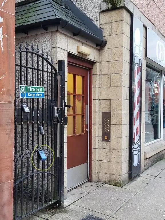 a door to a store with a sign on it at Inverness City Centre Apartment with Elevator and Google Chromecast in Inverness