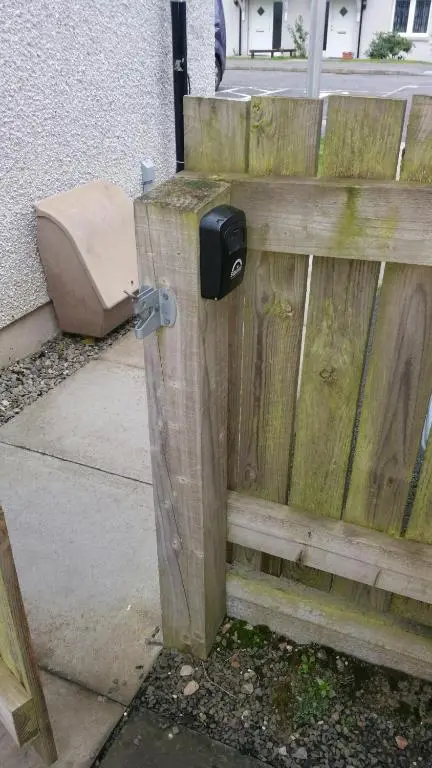 a mailbox on the side of a wooden fence at Lerwick Garden Apartment in Inverness