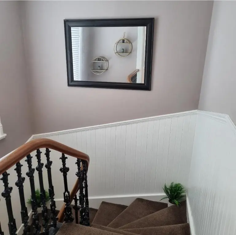 a mirror on a wall next to a staircase at City Centre Flat, Harbour View in Inverness