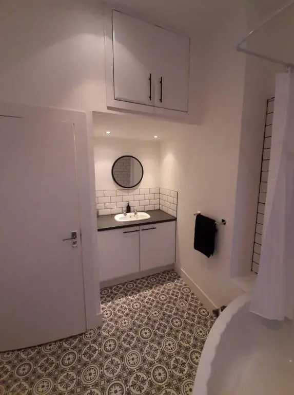 a white bathroom with a sink and a mirror at City Centre Flat, Harbour View in Inverness