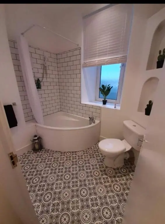 a bathroom with a tub and a toilet and a sink at City Centre Flat, Harbour View in Inverness