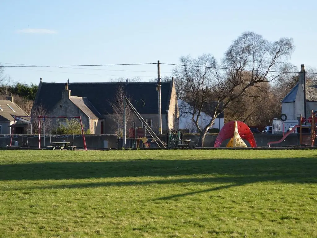 a park with a playground with a slide and a tent at March Brown in Garmouth