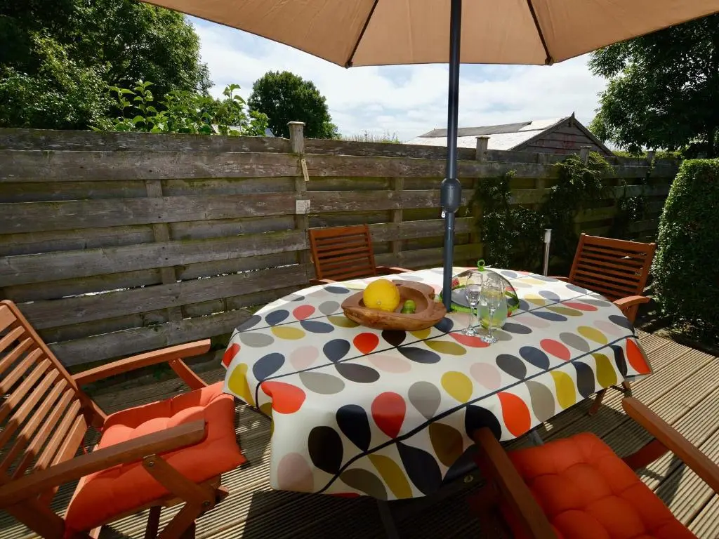 a table with a bowl of fruit and an umbrella at March Brown in Garmouth