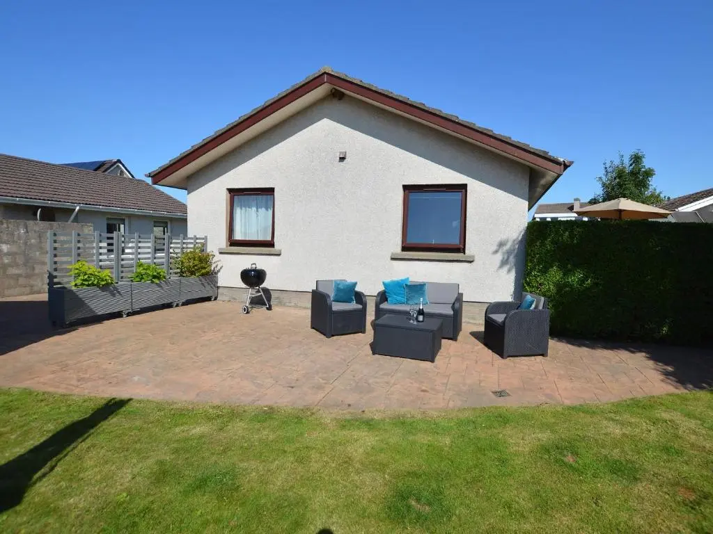 a patio with couches and chairs in front of a house at March Brown in Garmouth