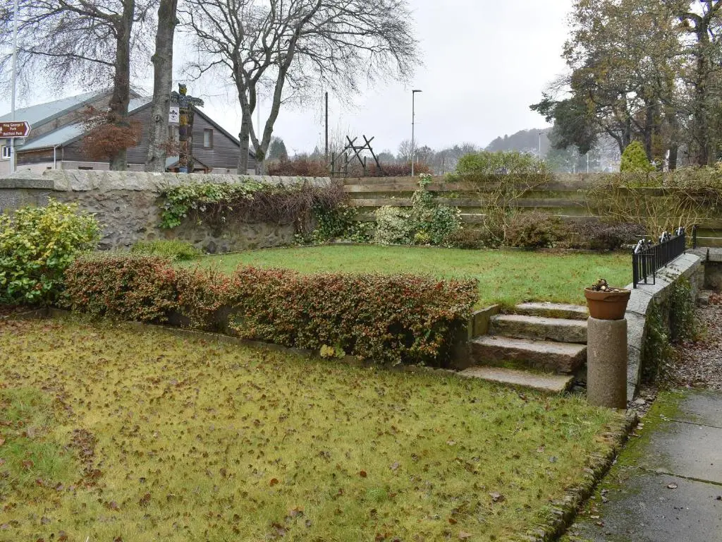 a garden with stairs and bushes in the grass at West Lodge in Banchory