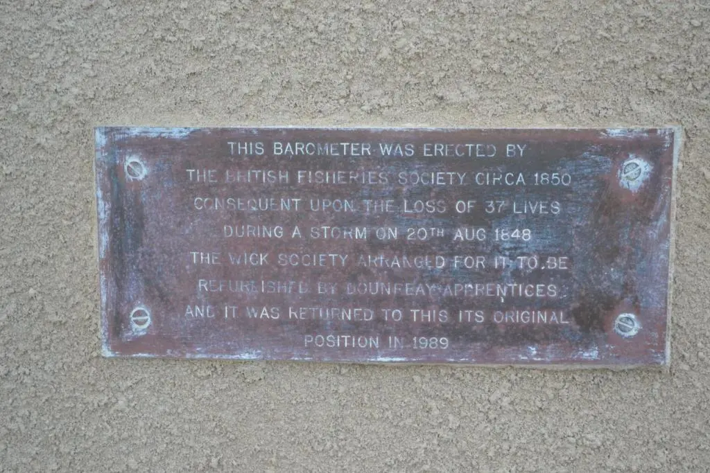a metal plaque on the side of a building at Harbour View Apartment Wick in Wick