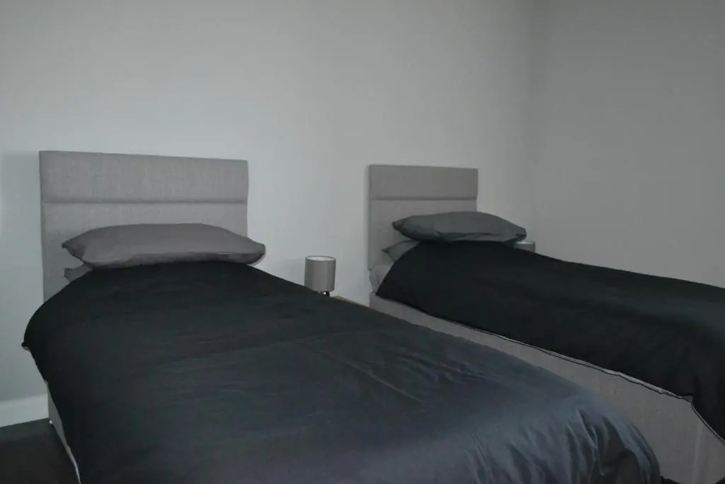 two beds sitting next to each other in a bedroom at Harbour View Apartment Wick in Wick