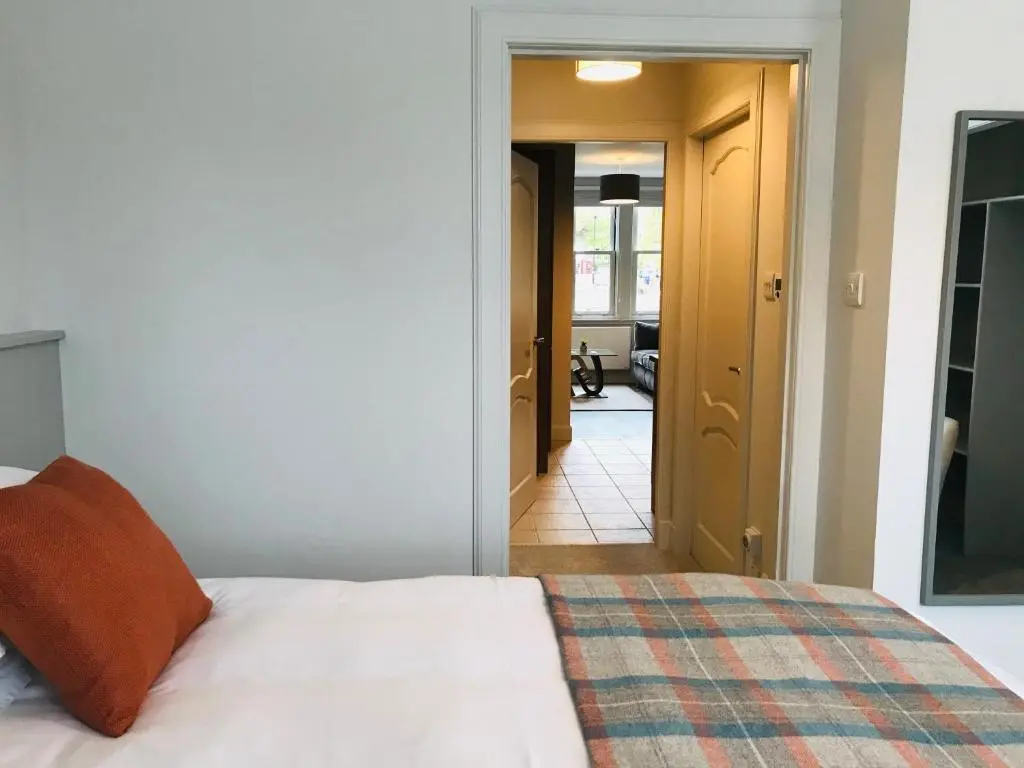 a bedroom with a bed and a hallway at 3 Argyle Place in Dornoch