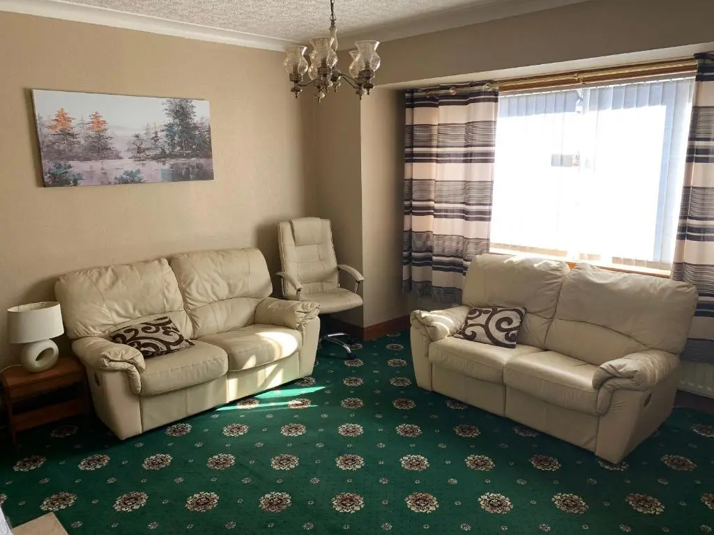 a living room with a couch and a chair at Lyndon Guest House in Inverness