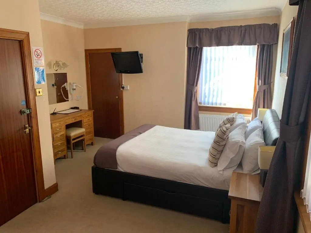 a hotel room with a bed and a window at Lyndon Guest House in Inverness