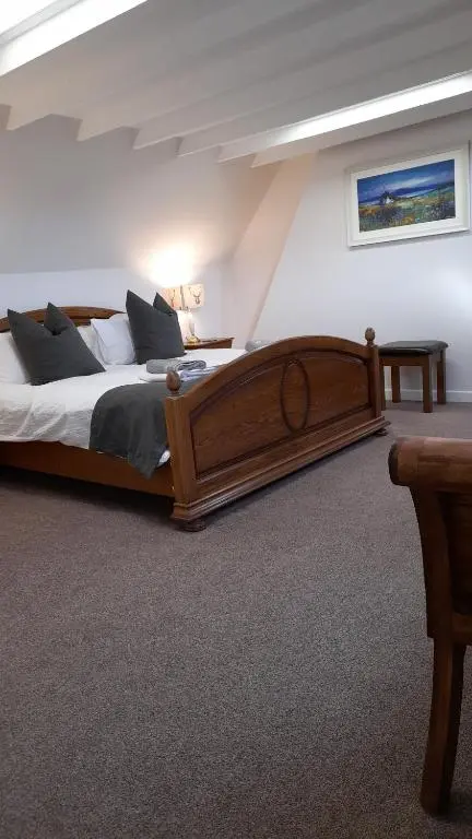 a bedroom with a large wooden bed in a room at The Dookit - Aviemore Town House in Aviemore