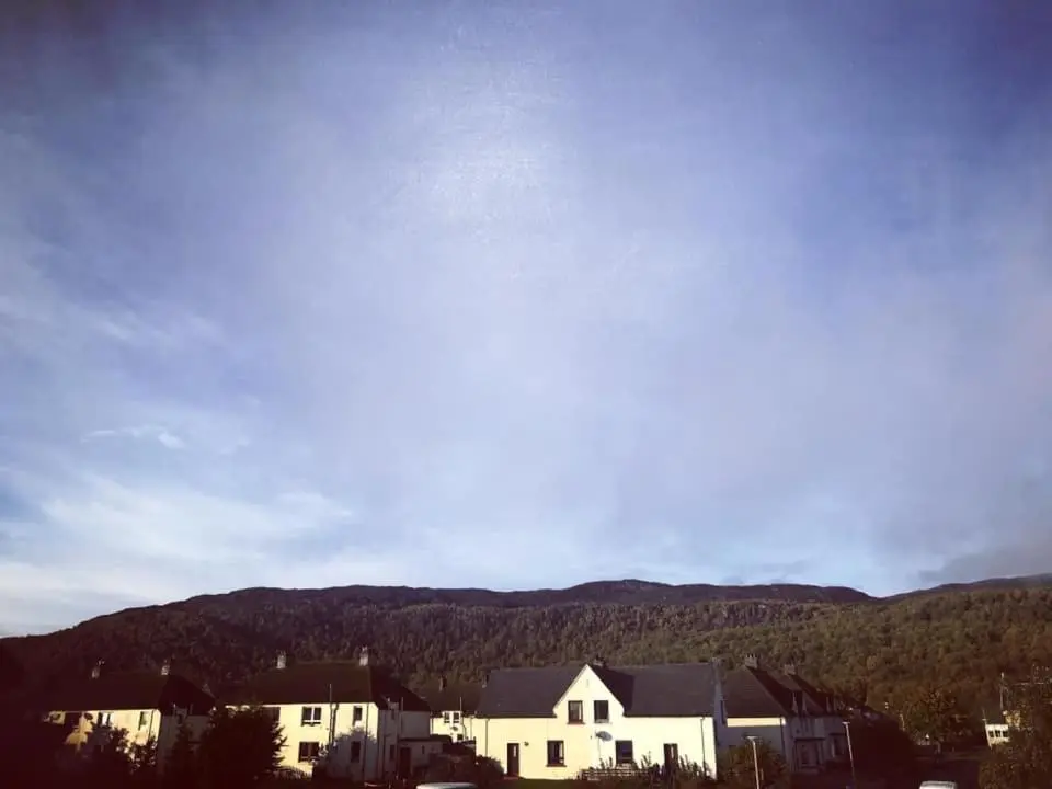 a group of houses with mountains in the background at The Dookit - Aviemore Town House in Aviemore