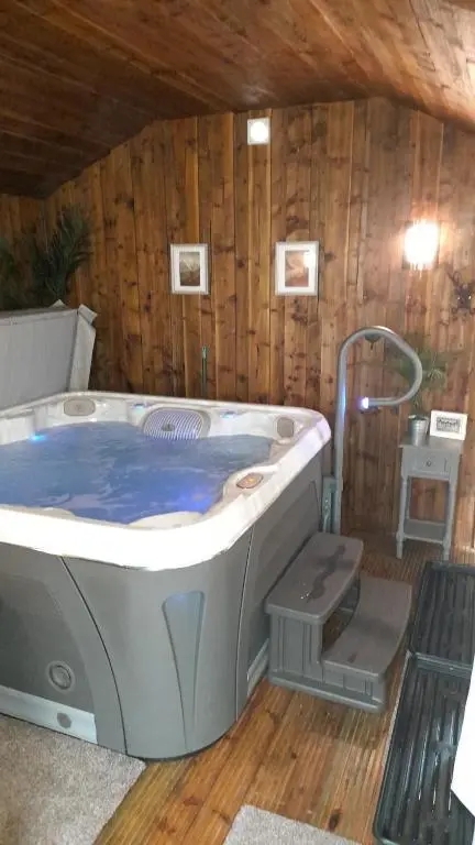 a large hot tub in a room with a bench at The Dookit - Aviemore Town House in Aviemore