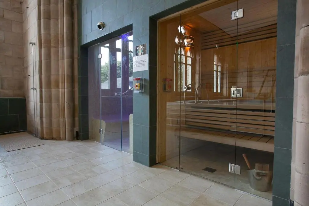 a bathroom with a glass shower in a building at Loch Ness Abbey Cottages in Fort Augustus