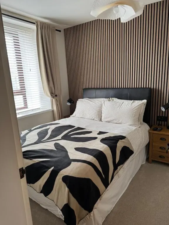 a bedroom with a bed with a black and white comforter at Church view in Wick