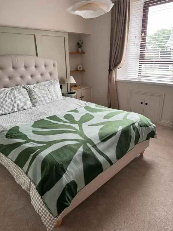 a bedroom with a bed with a green and white comforter at Church view in Wick
