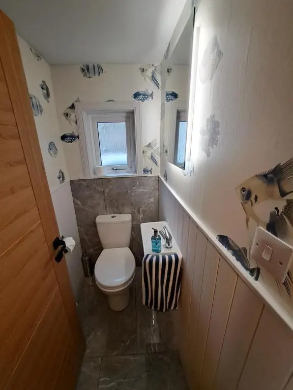 a small bathroom with a toilet and a window at Church view in Wick