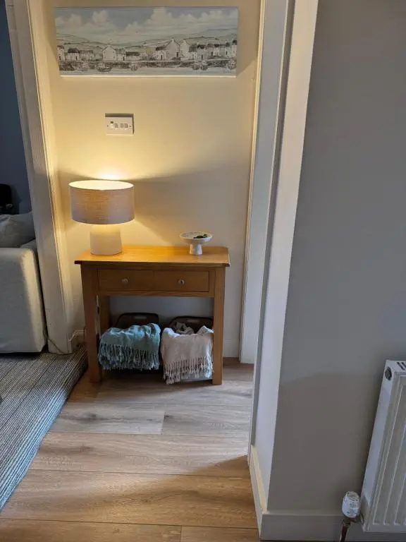 a room with a table with a lamp on it at Church view in Wick