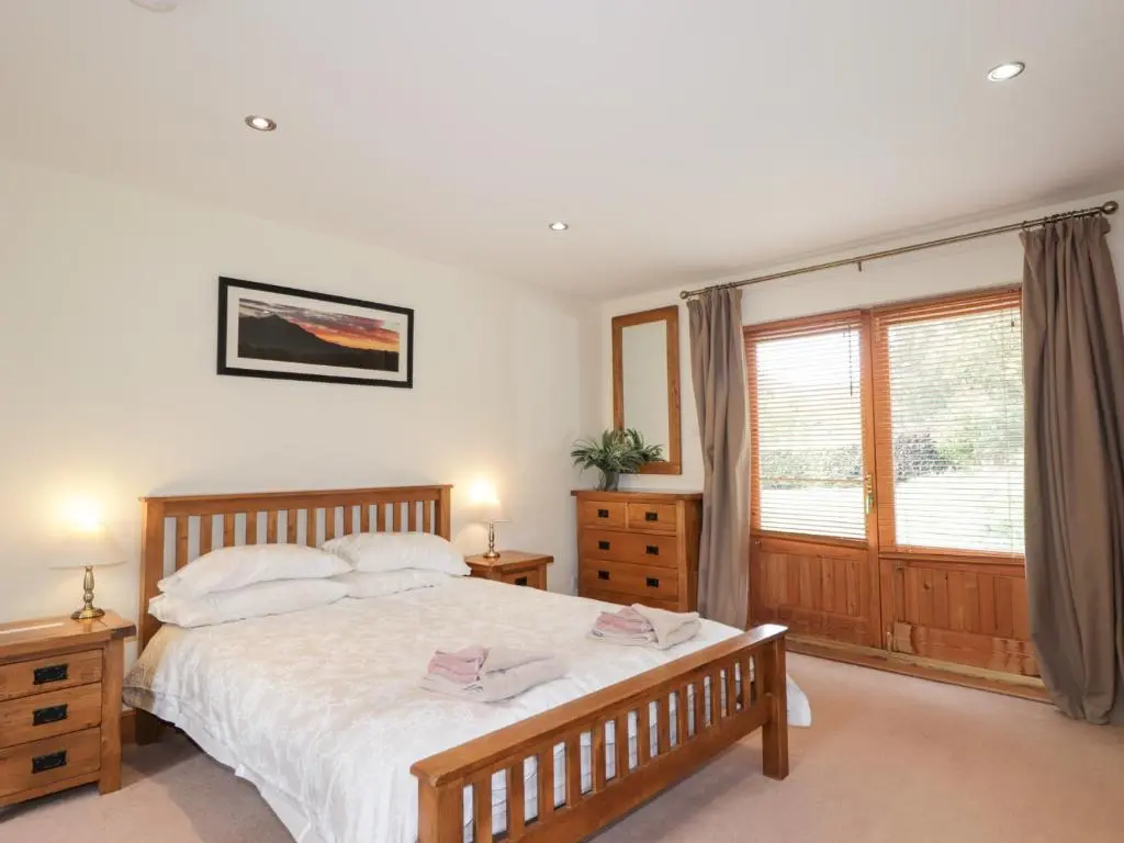 a bedroom with a large bed and a window at An Torr in Newtonmore