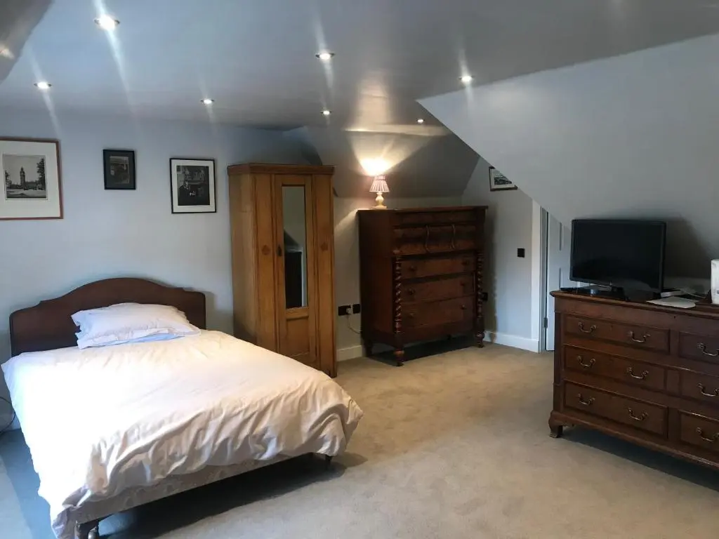 a bedroom with a bed and a dresser with a television at Kilmorie House in Elgin