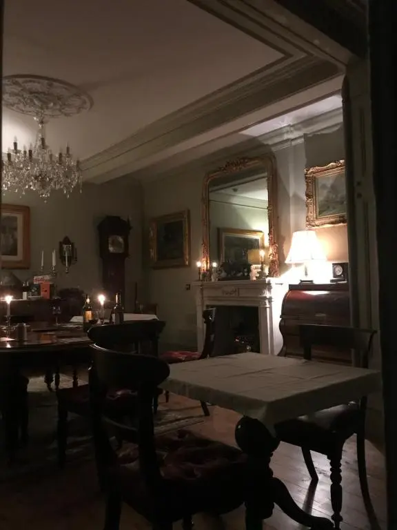 a living room with a table and a fireplace at Kilmorie House in Elgin
