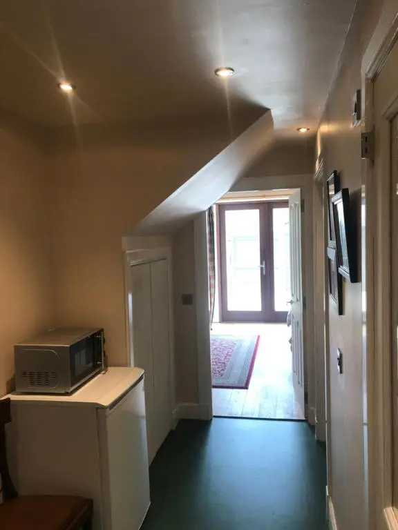 a kitchen with a microwave on a counter and a hallway at Kilmorie House in Elgin