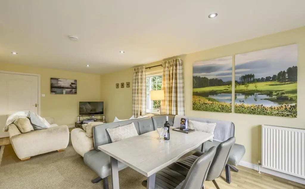 a living room with a table and a couch at Apartment 20 Inchmarlo in Banchory