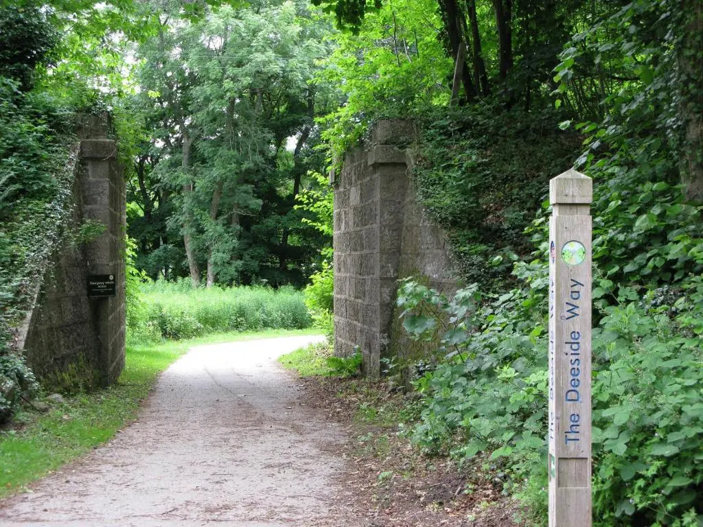 a sign on a dirt road next to a stone bridge at Apartment 20 Inchmarlo in Banchory
