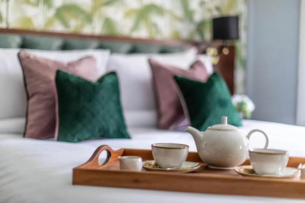 a tray with two cups and a tea set on a bed at Blackfriars in Inverness