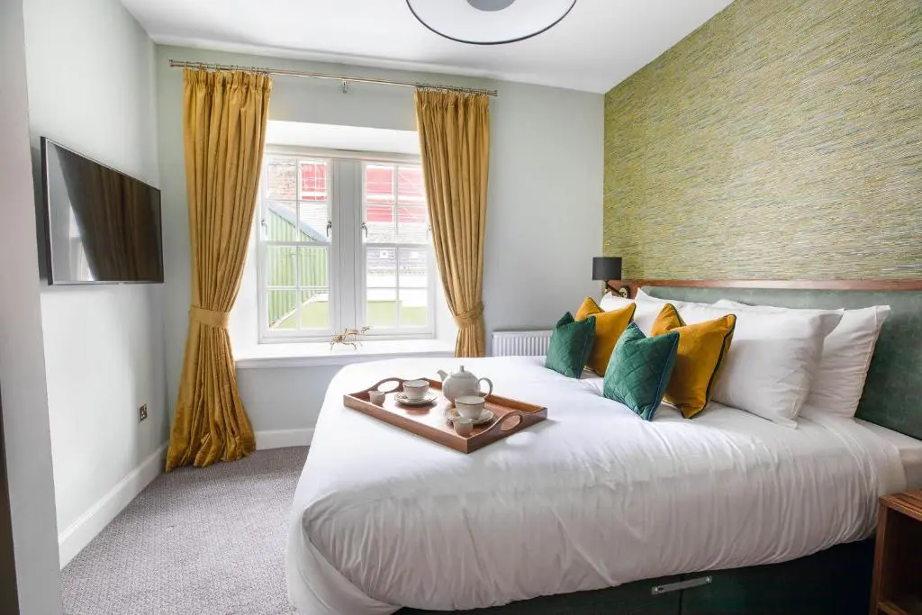 a bedroom with a large white bed and a window at Blackfriars in Inverness